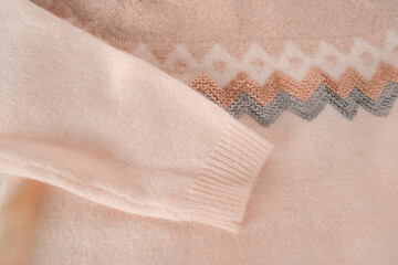beige wool jumper with cashmere geometric pattern, concept gentle washing and care of knitwear, protection against moth larvae