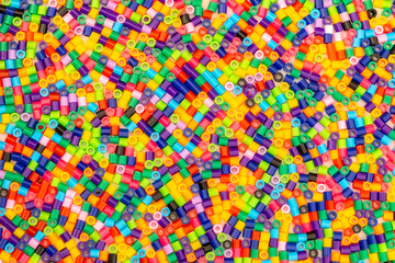 Pile of multicoloured bright Hama beads also known as craft beads for making cute designs before...