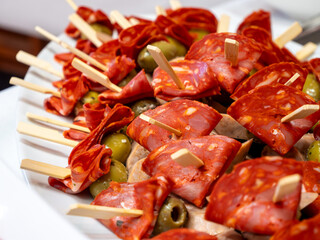 Small bites featuring salsicca chili sausage, olives, and ham served as appetizers in the restaurant