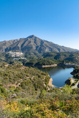 a portrait image of the reservoir and dam found behind the town of Marbella in Andalucia 