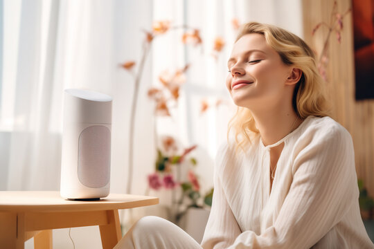 Pretty woman enjoy the music at the modern desktop speaker