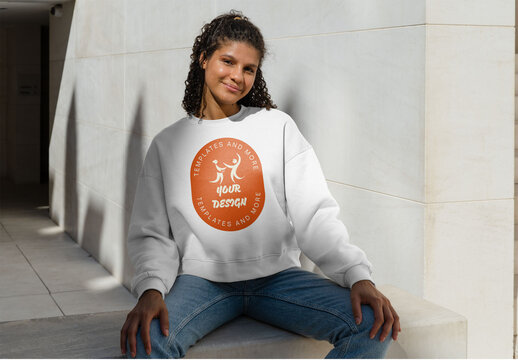 Mockup of woman wearing customizable sweatshirt on wall, smiling