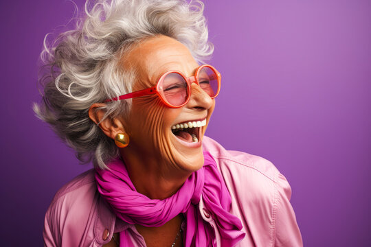 Elderly Woman Laughing Heartily On Bright Purple Background.