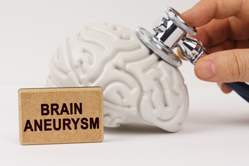 Using a stethoscope, the brain is diagnosed, next to it is a sign with the inscription - Brain aneurysm