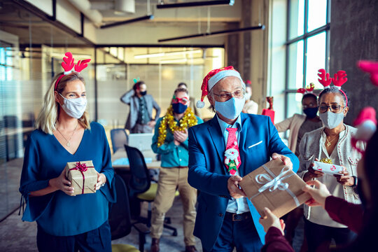Business colleagues giving Christmas present to each other in office