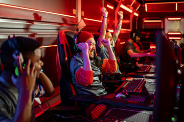 Professional gamer team celebrating victory raising hands