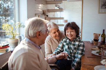 Happy little boy having fun with grandparents at home