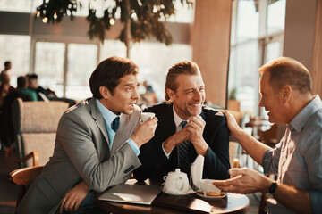 Businessmen Engaged in Discussion Over Coffee