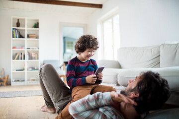 Father playing with little son at home