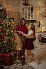  teenage sisters twins at home in the kitchen waiting for the New Year