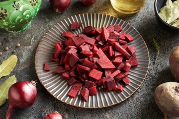 Slices of beetroot on a black plate - preparation of fermented beet kvass - obrazy, fototapety, plakaty