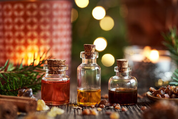Obraz na płótnie Canvas Christmas selection of essential oils with myrrh, frankincense, cinnamon and candle