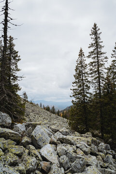 Big grey kurumnik on the mountain, mountain range, cloudy weather, stone slope of mountain peak, autumn landscape.