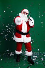 Full size photo of mature pensioner man microphone sing point you wear trendy santa claus costume coat isolated on green color background