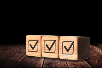 Check mark for jobs list on wooden blocks.