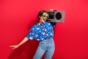 Photo of carefree crazy person carry boombox have fun dancing chilling isolated on bright red color background