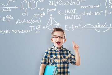 Smiling child student boy with mathematical symbols