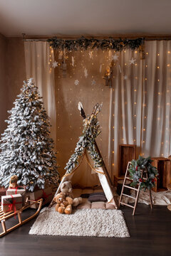 Children's room decorated in Christmas style. Wooden sleigh, gifts and hut for children to play.