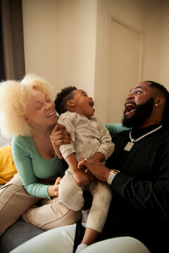 Happy African family hanging out in living room and laughing