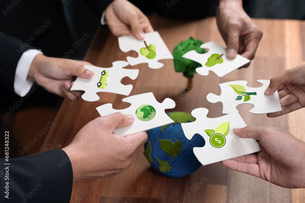 Wall mural cohesive group of business people holding eco icon jigsaw puzzle pieces around globe earth as eco co