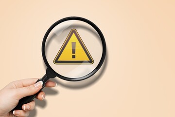 Hand holding Exclamation mark yellow Warning sign