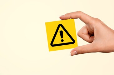 Hand holding Exclamation mark yellow Warning sign