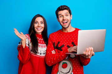 Photo portrait of attractive young couple amazed netbook eshop wear x-mas ornament red sweaters...