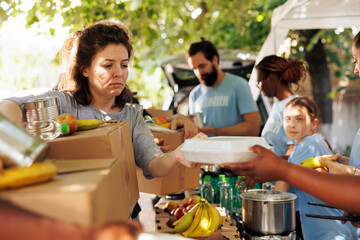Diverse group provides aid, handing out meals to poor and needy individuals. Volunteers of all...