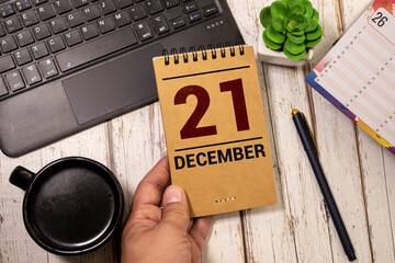 Cube calendar with date 21 DECEMBER, Christmas balls and gift on beige background