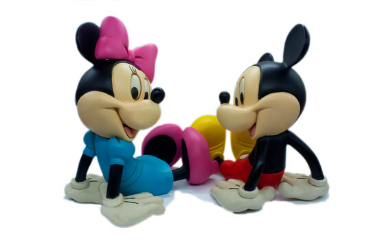 Studio image of Mickey and Minnie sitting with shadow on a white isolated background.