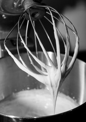 Whipped cream in an electric mixer.