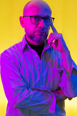 Bald, bearded man wearing glasses gesturing with his hands.