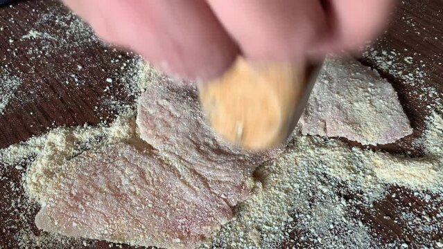 Video of hands preparing chicken milanesa. Food preparation concept.
