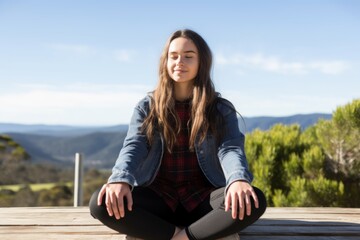 Fototapeta na wymiar Front portrait young relaxed calm sporty Caucasian lady woman female sitting outside eyes closed practicing yoga mindful meditation lotus pose wellbeing doing workout fitness soul mental health stress