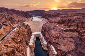 Hoover Dam on the Colorado River straddling Nevada and Arizona at dawn from above.