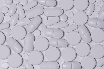 Detalle de varios comprimidos de uso medicinal sobre fondo blanco