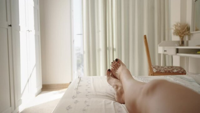 Bright and Sunny Bedroom, First-person View of a Woman's Legs Being Caressed by a Man's Hand, Slowly Revealing Them. Concept of Romantic Relationships.