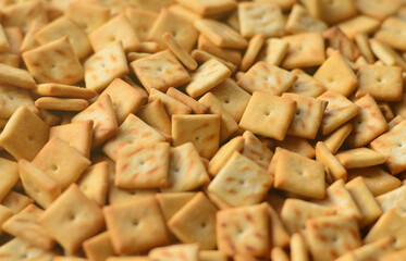 Background texture of small edible squares baked from dough and sprinkled with salt. A lot of salt cracker