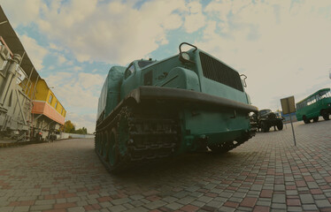 Photo of a Russian green armored car on a caterpillar track among the railway trains. Strong...