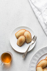 top view of lemon vanilla madeleines on a white plate, plain french vanilla madeleine cake or cookies
