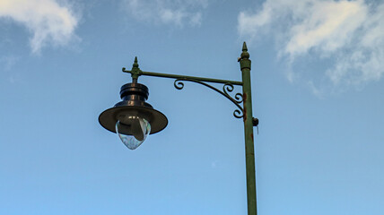 "Lamp post against a blue sky background."