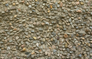 The texture of a strong stone wall of many concreted stones of various shapes