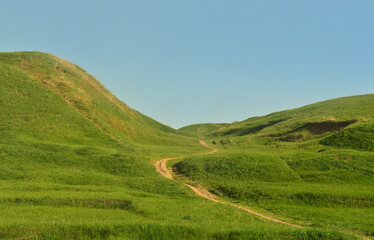 Landscape with a trampled path, passing through a wonderful green mountainous terrain. Photo of...