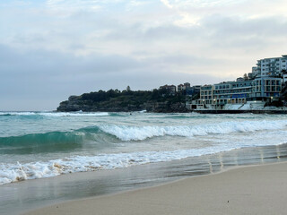 Ocean's Embrace: Waves at Bondi Beach with Majestic Villas