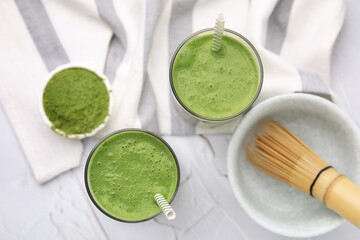 Glasses of tasty matcha smoothie on white textured table, flat lay