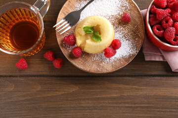 Tasty vanilla fondant with white chocolate and raspberries served on wooden table, flat lay. Space...