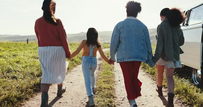 Happy, skipping and family holding hands outdoor on path, road trip or countryside nature. Excited, energy and people together with freedom, happiness and bonding on adventure, journey or walking