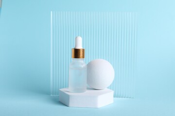 Stylish presentation of cosmetic serum on light blue background