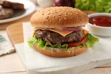 Tasty hamburger with patty, cheese and vegetables on light table, closeup