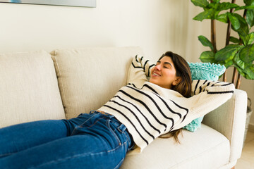 Beautiful latin young woman relaxing on the cozy couch